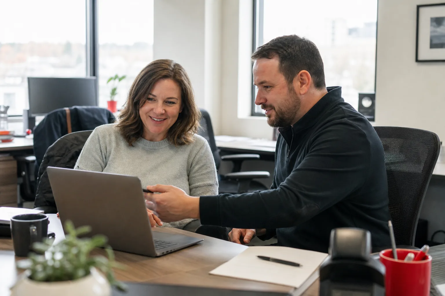 An employee and IT specialist resolving a workplace technology issue